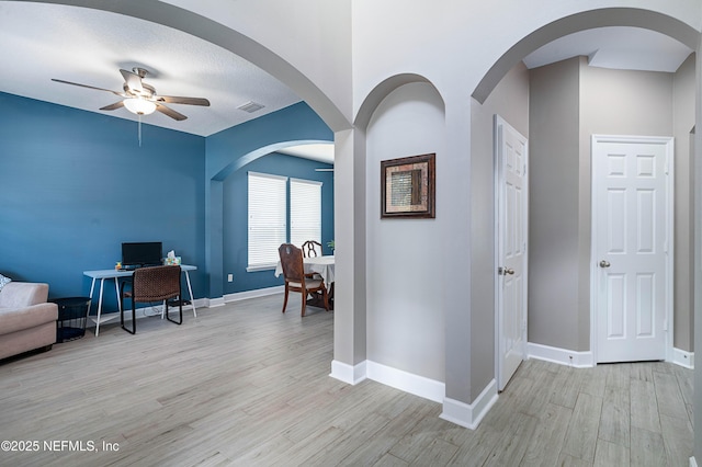 interior space with baseboards, light wood-style flooring, and visible vents