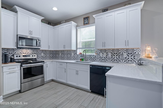 kitchen featuring light wood-style floors, white cabinets, tasteful backsplash, a sink, and stainless steel appliances
