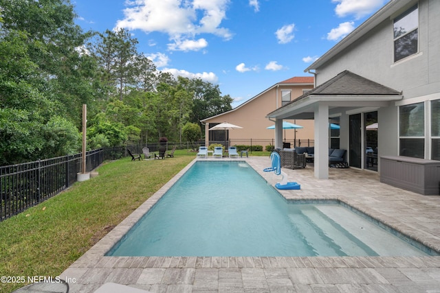 view of swimming pool with a patio, a fenced backyard, outdoor lounge area, and a yard