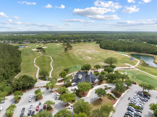 drone / aerial view featuring a forest view, a water view, and golf course view