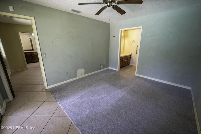 861 Hibernia Forest Dr, Fleming Island, FL 32003 - unfurnished bedroom with a textured ceiling, ensuite bath, tile patterned flooring, a ceiling fan, and baseboards