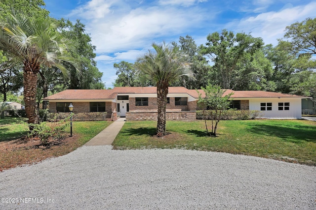 ranch-style home with a front lawn and brick siding