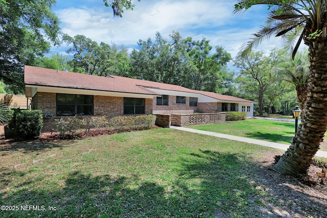 tri-level home with brick siding and a front yard