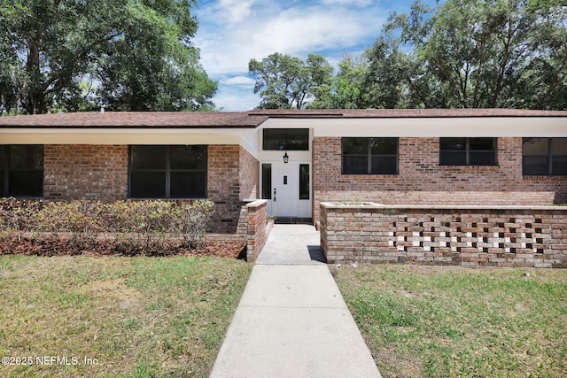 view of front of house featuring a front lawn and brick siding