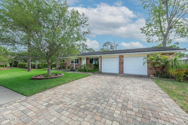 ranch-style house featuring an attached garage, decorative driveway, a front yard, and brick siding