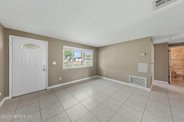 entryway with visible vents, baseboards, and light tile patterned floors