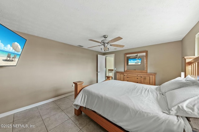 bedroom with ceiling fan, a textured ceiling, visible vents, baseboards, and light tile patterned flooring