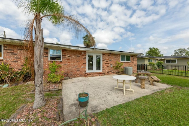 rear view of house with fence, cooling unit, french doors, a patio area, and a yard