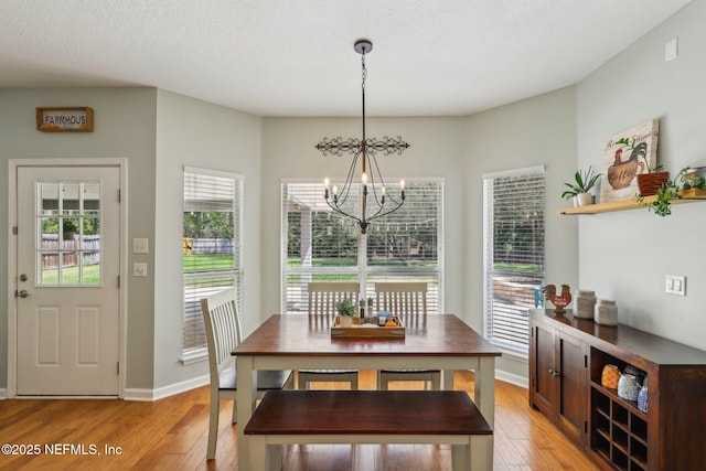 dining space featuring plenty of natural light, light wood-type flooring, and a chandelier