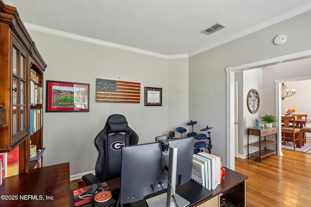 office featuring a chandelier, ornamental molding, wood finished floors, and visible vents
