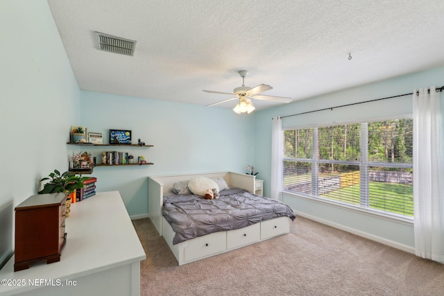 carpeted bedroom featuring visible vents, a textured ceiling, ceiling fan, and baseboards