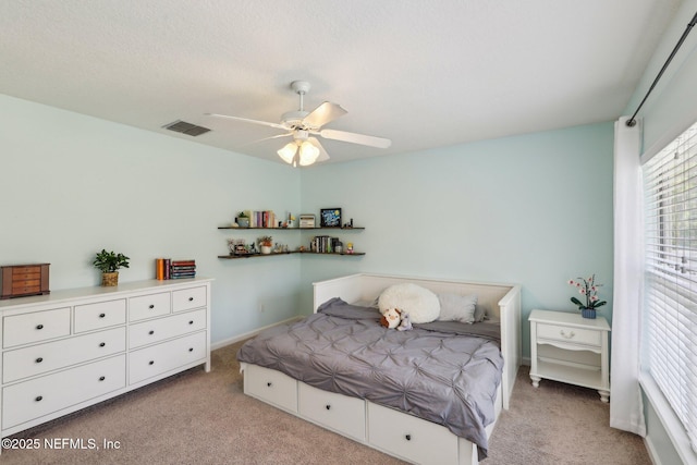 bedroom featuring visible vents, baseboards, ceiling fan, and light carpet
