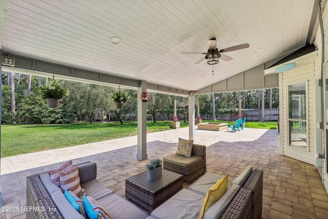 view of patio / terrace with a fenced backyard, an outdoor living space with a fire pit, and a ceiling fan