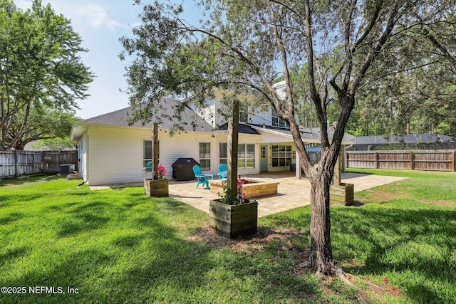 back of property with a patio, a fenced backyard, and a lawn