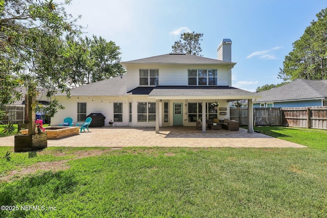 back of property featuring a fenced backyard, an outdoor hangout area, a chimney, a patio area, and a lawn
