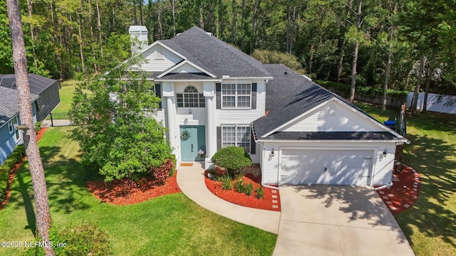 view of front of property featuring a garage, fence, a front yard, a chimney, and concrete driveway