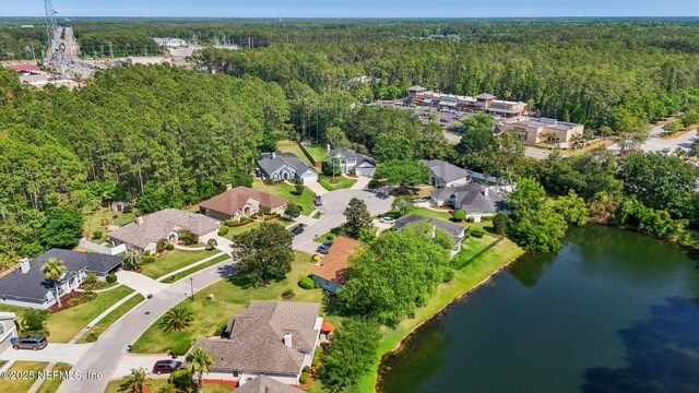 drone / aerial view with a water view, a residential view, and a wooded view