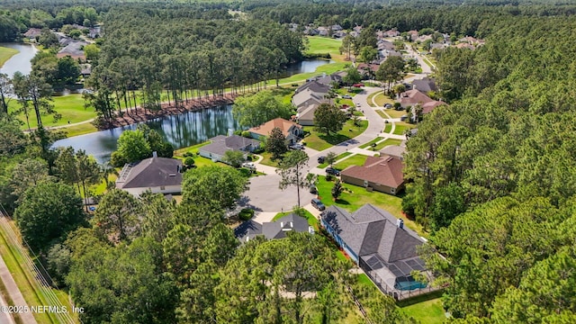 birds eye view of property featuring a water view, a view of trees, and a residential view