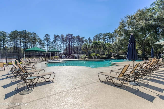 community pool featuring fence and a patio area