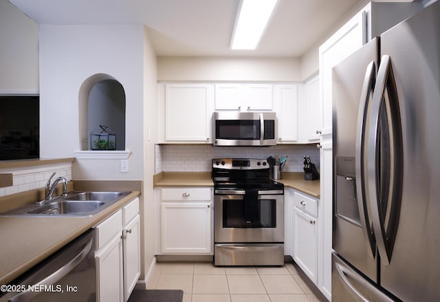 kitchen featuring white cabinetry, a sink, backsplash, and appliances with stainless steel finishes