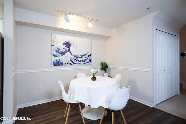 dining area featuring track lighting, wood finished floors, and baseboards