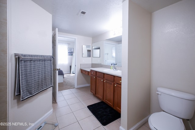 bathroom with tile patterned flooring, visible vents, toilet, vanity, and baseboards