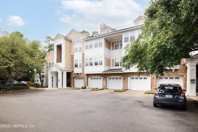 multi unit property featuring driveway and stone siding