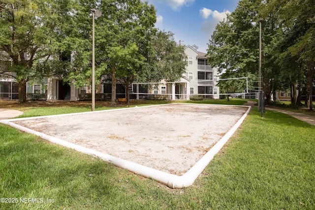 surrounding community featuring volleyball court and a lawn