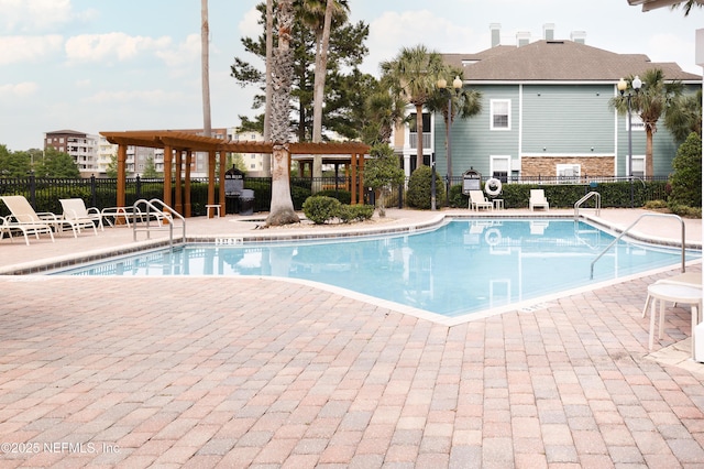 pool with a pergola, a patio, and fence