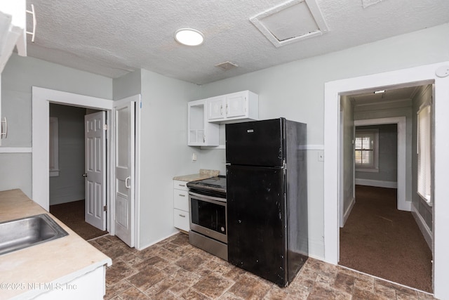 1488 W 5th St, Jacksonville, FL 32209 - kitchen featuring white cabinets, light countertops, a sink, freestanding refrigerator, and stainless steel range with electric stovetop