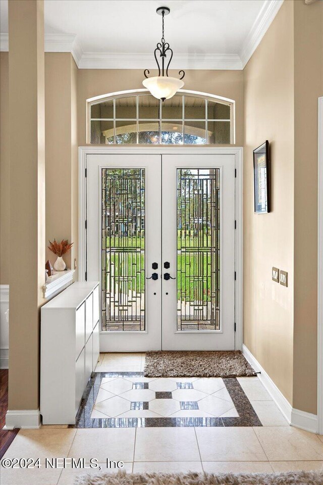 entrance foyer featuring baseboards, tile patterned flooring, and ornamental molding