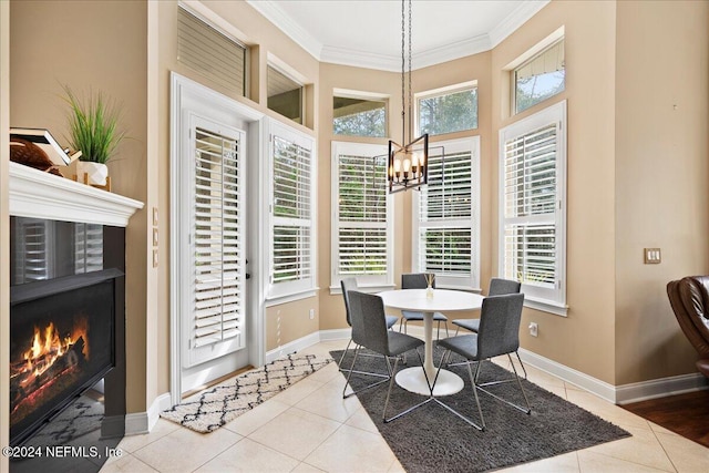 dining space featuring baseboards, tile patterned flooring, a lit fireplace, and crown molding