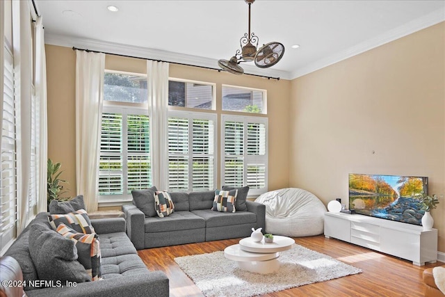 living room featuring ornamental molding, a healthy amount of sunlight, a chandelier, and wood finished floors