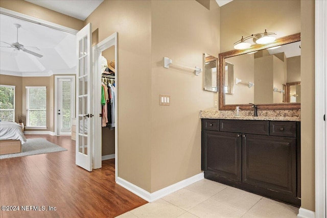 bathroom with baseboards, a spacious closet, wood finished floors, ceiling fan, and vanity