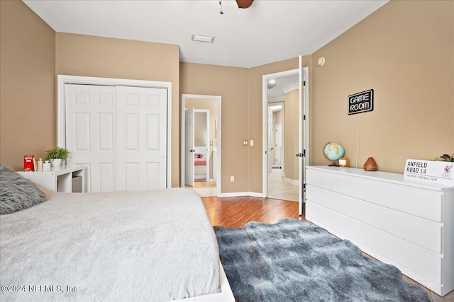 bedroom featuring wood finished floors, a closet, baseboards, and ceiling fan
