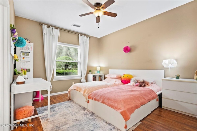 bedroom featuring wood finished floors, visible vents, a ceiling fan, and baseboards