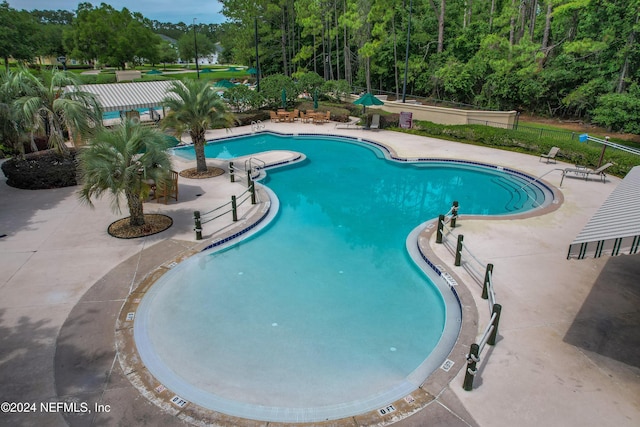 community pool featuring fence and a patio area