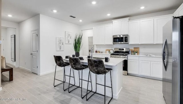 335 Dogleg Run, Saint Johns, FL 32259 - kitchen featuring stainless steel appliances, light countertops, a breakfast bar area, a center island with sink, and recessed lighting