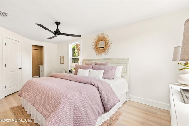 bedroom featuring ceiling fan, baseboards, visible vents, and light wood-style flooring