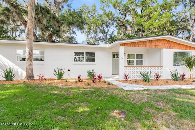 single story home featuring a porch and a front lawn
