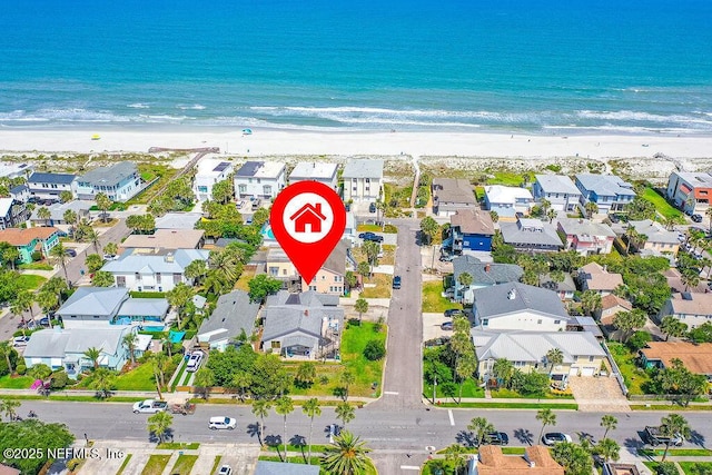 aerial view of property and surrounding area featuring extended coastline and nearby suburban area