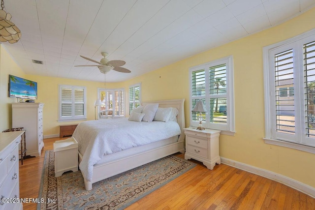 bedroom featuring light wood-style flooring, a ceiling fan, and baseboards