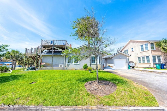 view of front of house featuring stucco siding, a front yard, asphalt driveway, and a garage