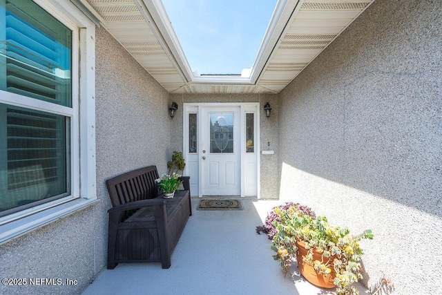 entrance to property featuring stucco siding