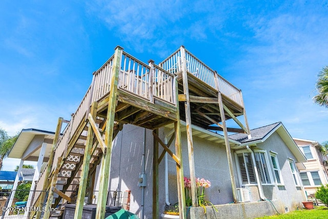 rear view of property with stairs, a wooden deck, stucco siding, and cooling unit