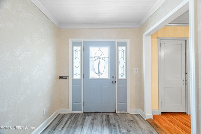 foyer featuring wood finished floors, baseboards, and ornamental molding