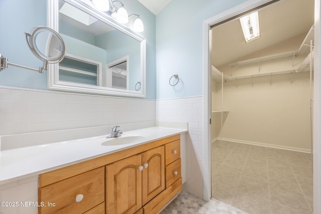 bathroom featuring vanity, a spacious closet, and tile patterned floors