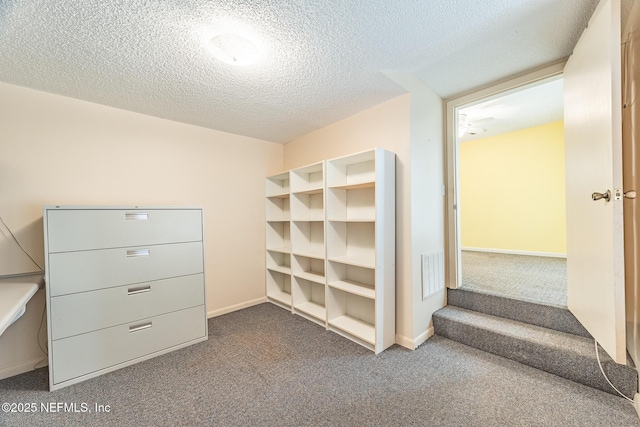 walk in closet featuring dark carpet