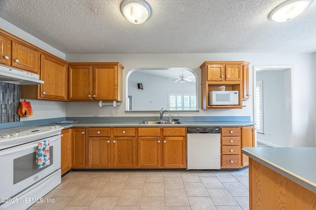 kitchen with white appliances, a sink, under cabinet range hood, a ceiling fan, and a textured ceiling