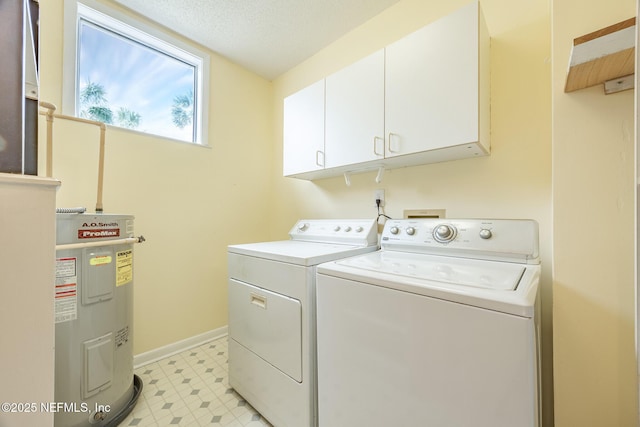 laundry area with cabinet space, water heater, separate washer and dryer, light flooring, and baseboards